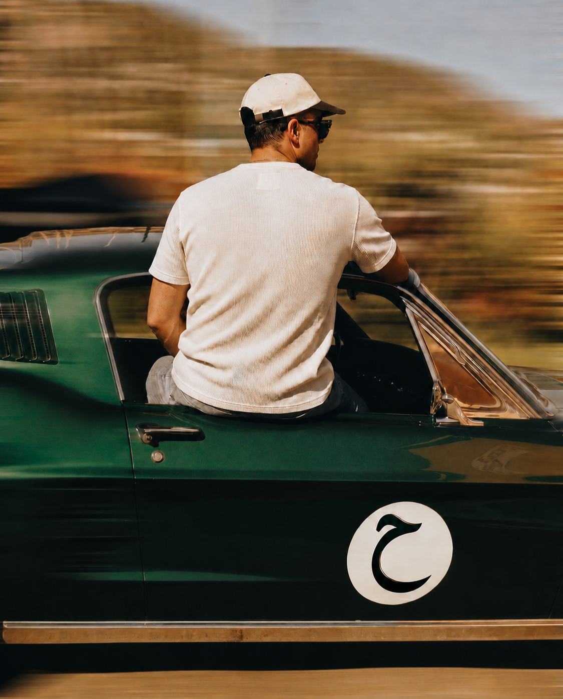 HAFEZ hero - man in white Henley on green racing car